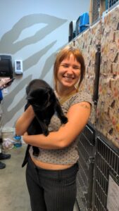 OliveA black cat named Olive held safely inside a cat rescue adoption room.